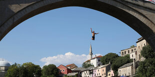 Ein Turmspringer springt vom Bogen der Alten Brücke in Mostar