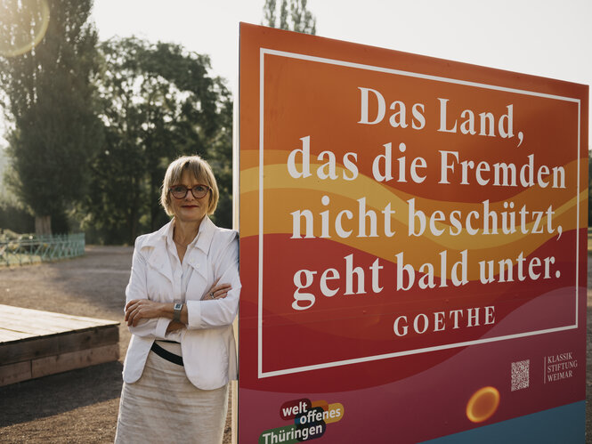 Ulrike Lorenz steht vor einem Schild mit Goethe-Zitat