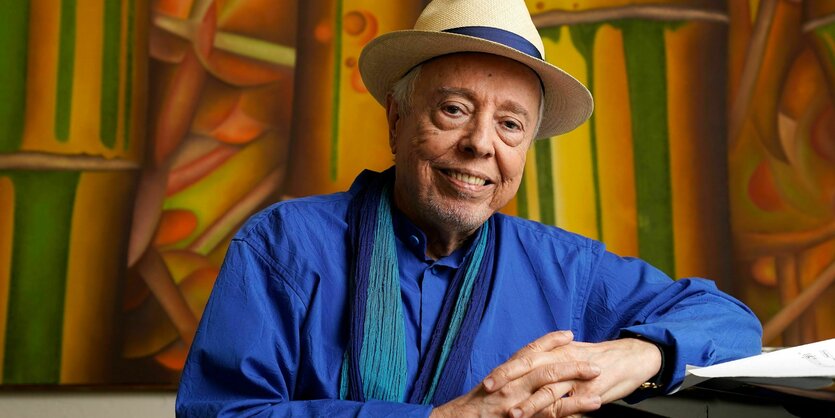 Sergio Mendes lehnt mit dem Ellbogen an einem Klavier