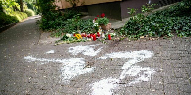 Kerzen und Blumen stehen und liegen in Berlin-Zehlendorf am Tatort