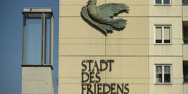 Ein gekachelte Wand an einem Hochhaus im Berliner Nikolaiviertel zeigt eine stilisierte Friedenstaube und den Schriftzug Stadt des Friedens