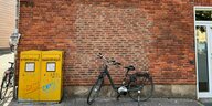 Ein Fahrrad steht vor einer Filiale der Postbank, die als Postfiliale fungiert. Auf zwei gelben Briefkästen steht "Endstation Sehnsucht".