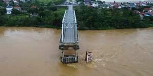 Der Rest einer Stahlbrücke über einen Fluss, die andere Hälfte stürzte in den Fluss