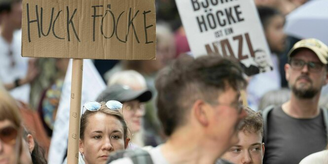 Menschen demonstrierenmit einm Plakat auf dem steht: "Huck Föcke"