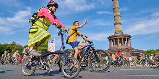 Radfahrer in bunter Kleidung vor der Siegessäule