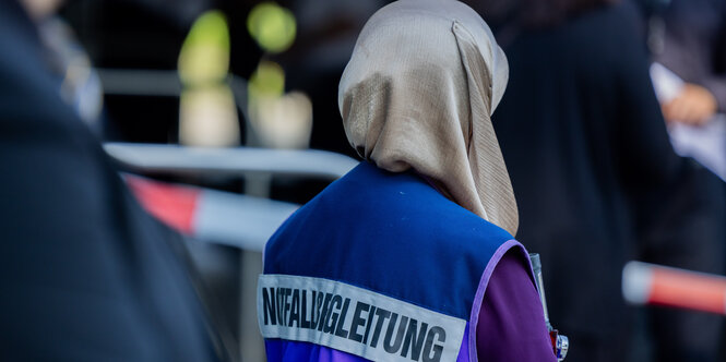 Eine Notfallbegleiterin mit Kopftuch steht vor dem Theater- und Konzerthaus, wo die Gedenkfeier nach dem Anschlag auf dem Solinger Stadtfest stattfinden wird.