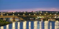 Die Carolabrücke in Dresden mit der eingestürzten Fahrbahn, erleuchtet im Abendlicht