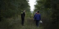 Ein Polizist neben Geflüchteten an der Grenze zu Polen.