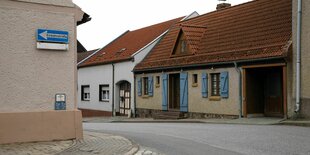 Einstöckige geduckte Häuser stehen an der Straße, die Häuser wirken frisch renoviert - niemand ist auf der Straße