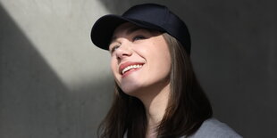 Porträtbild der Autorin Laura Wrobel alias the.real.lauri mit Basecap und im Halbschatten