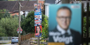 Wahlplakate hängen in einem kleinen Dorf in Thüringen, im Vordergrund unscharf Mario Voigt, im Hintergrund an der Straße sind Afd und SPD Plakate zu sehen