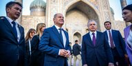 Bundeskanzler Olaf Scholz auf dem Registan-Platz vor der Tilla-Kari Moschee in Samarkand, zusammen mit dem usbekischen Präsidenten Schawkat Mirsijojew und weiteren Menschen