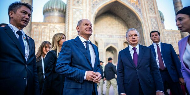 Bundeskanzler Olaf Scholz auf dem Registan-Platz vor der Tilla-Kari-Moschee in Samarkand, gemeinsam mit dem usbekischen Präsidenten Shavkat Mirziyoyev und weiteren Personen