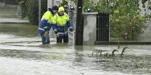 Zwei Männer stehen in einem überfluteten Gebiet in Pottenbrunn in St. Pölten.