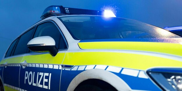 Aufnahme eines Polizeiautos in der Abenddämmerung mit blinkendem oberen Blaulicht