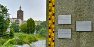 Der deutsch-polnische Grenzfluss Neiße im Stadtzentrum von Guben. An der rechten Bildseite ist eine Pegelmarkierung zu sehen, mit einer Plakette am oberen Rand, die das Hochwasser aus dem Jahr 2010 mit 4,57 Meter markiert.