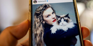 Taylor Swift mit einer Katze auf dem Arm, zu sehen auf einem Mobiltelefon.