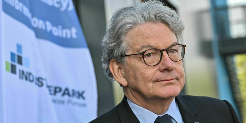 Porträt von Thierry Breton, das graue Haar ist wellig, er trägt eine Brille und schaut skeptisch in die Kamera