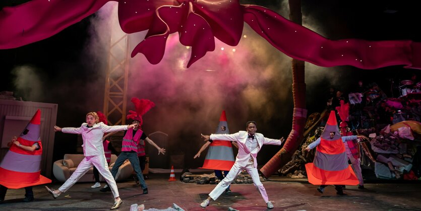 Blick auf die Bühne von "GRMPF" im KÖlner Schauspielhaus mit schwebender Schleife und tanzenden Absperrhütchen