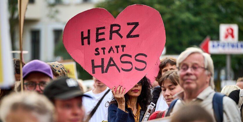 Demonstrierende mit einem Herz und der Aufschrift "Herz statt Hass"