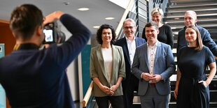 Die sechs SPD-Mitglieder stehen auf einer Treppe und werden von einem Fotografen fotografiert