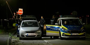 Polizisten kontrollieren in der Nacht Fahrzeuge an der Grenze zu Belgien