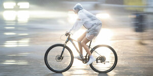 Ein Fahrradfahrer mit Regencape