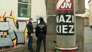 Polizisten stehen vor der Gaststätte «Bull's Eye». An einem Pfahl ist ein Aufkleber mit der Aufschrift «Nazi Kiez» zu sehen.