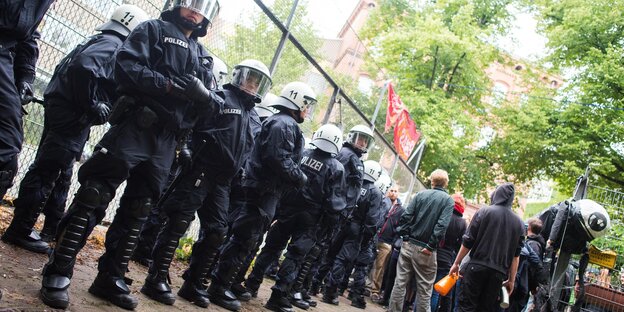 Eine Polizeikette vor einem Zaun