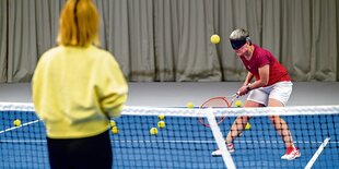 Kirstin Linck steht auf einem Tennisplatz und schlägt auf einen Ball