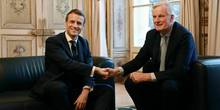 Der französiche Präsident Emmanuel Macron schüttelt Michel Barnier dei Hand