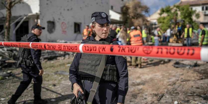 Uniformierte Person vor an einem zerstörten Ort.