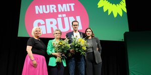 Alexandra Pichl, Antje Töpfer, Benjamin Raschke und Hanna Große Holtrup mit Blumen auf einer Bühne mit der Aufschirft "Nur mit Grün"