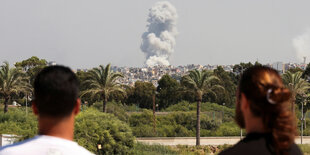 Menschen beobachten, wie nach israelischen Angriffen Rauch über dem Südlibanon aufsteigt.