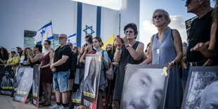 Angehörige von Geiseln halten Schilder mit Fotos ihrer Liebsten auf einer Demonstration in Tel Aviv