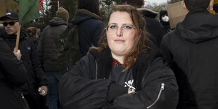 Eine Frau guckt während einer Demonstration selbstbewusst in die Kamera.