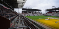 Blick ins leere Millerntorstadion, über dessen Rasen eine Beleuchtungsanlage fährt