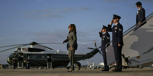 Kamala Harris ist aus einem Flugzeug ausgestiegen, Militärs eskortieren die Treppe