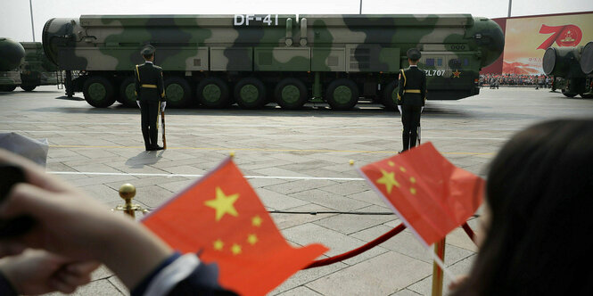 Zuschauer schwenken chinesische Flaggen, während Militärfahrzeuge mit DF-41-Atomraketen während einer Parade zum 70. Jahrestag der Gründung des kommunistischen Chinas in Peking am 1. Oktober 2019 vorbeifahren.