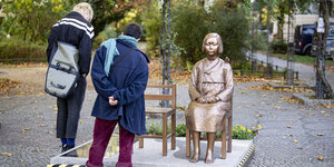 Zwei Frauen stehen vor der "Friedensstatue" in Moabit-Berlin.