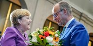 Friedrich Merz überreicht Angela Merkel Blumen