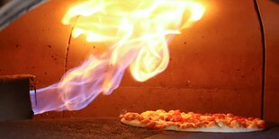 Pizza unter Flammen im Ofen