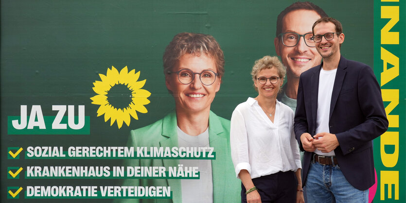 Grünen-Politiker vor einem Wahlplakat