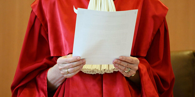 Eine Verfassungsrichterin hält ein Blatt Papier in den Händen