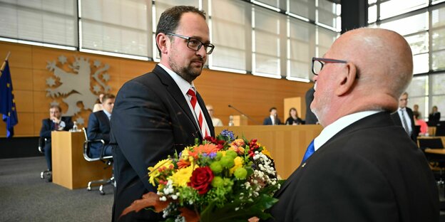 Thadäus König bekommt von Jürgen Treutler einen Blumenstrauß gereicht