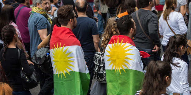 Zwei Demoteilnehmer mit kurdischen Flaggen
