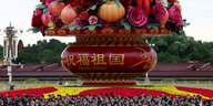 Teilnehmer stehen vor einer riesigen Blumenkorb-Installation am Vorabend des 75. Jahrestages der Gründung der Volksrepublik China auf dem Platz des Himmlischen Friedens in Peking, China, 30. September 2024.