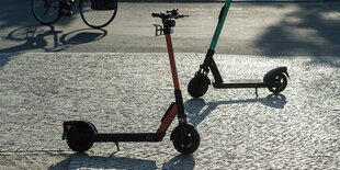 Zwei E-Scooter stehen auf dem Gehweg