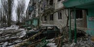 Ein zerstörtes Auto steht vor einem Wohnhaus in Wuhledar, das von den russischen Streitkräften schwer bombardiert wurde