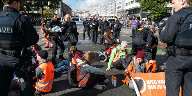 Protestierende werden von der Politei weggetragen